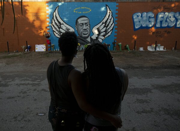 LaQuincia Pittman, left, and her wife Kaysi Higgins look at the George Floyd mural in Third Ward on Wednesday, June 3, 2020, in Houston. in Houston. Floyd died after being restrained by Minneapolis police officers on May 25.   (Godofredo A. Vásquez/Houston Chronicle via AP)