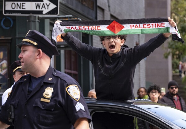A Palestinian supporter passes by supporters of Israel gathered near the Israeli Consulate in New York, Monday, Oct. 9, 2023, in the wake of an attack on Israel by Hamas militants. (AP Photo/Craig Ruttle, File)