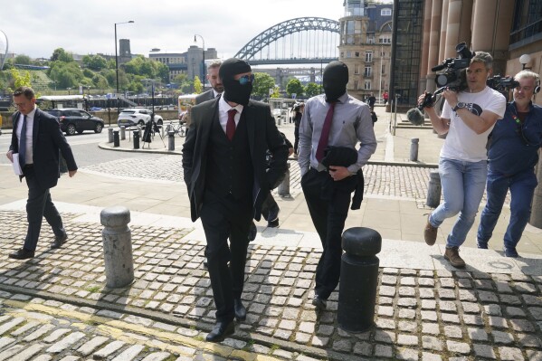 Daniel Graham foreground and Adam Carruthers, centre-right, leave Newcastle Upon Tyne Magistrates' Court after appearing in connection with the felling of the Sycamore Gap tree, in Newcastle-upon-Tyne, England, Wednesday, May 15, 2024. The men are charged with causing criminal damage and damaging the wall built in A.D. 122 by Emperor Hadrian to guard the northwest frontier of the Roman Empire. (Owen Humphreys/PA Wire/PA via AP)