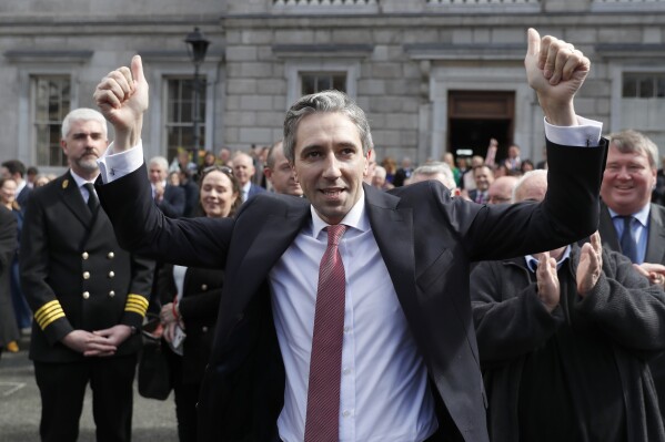 The new Prime Minister of Ireland, Simon Harris gestures as he is applauded by fellow lawmakers outside Leinster House, in Dublin, Ireland, Tuesday, April 9, 2024. Harris was selected after the previous Prime Minister Leo Varadkar resigned, he is the youngest ever Prime Minister of Ireland. (AP Photo/Peter Morrison)