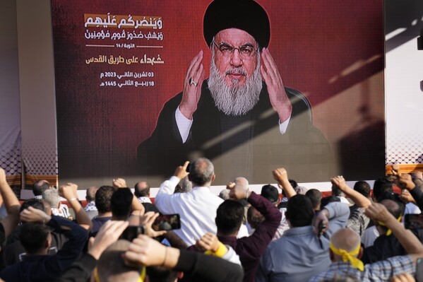 Hezbollah leader Sayyed Hassan Nasrallah greets his supporters via a video link, during a rally to commemorate Hezbollah fighters who were killed in South Lebanon last few weeks while fighting against the Israeli forces, in Beirut, Lebanon, Friday, Nov. 3, 2023. Nasrallah's speech had been widely anticipated throughout the region as a sign of whether the Israel-Hamas conflict would spiral into a regional war. (AP Photo/Hussein Malla)