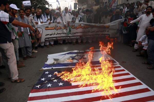 Supporters of Palestinian Foundation Pakistan burn representations of Israeli and American flags while chanting slogans against the Israeli airstrikes on Gaza during a demonstration to show solidarity with the Palestinian people, in Karachi Pakistan, Sunday, Oct. 8, 2023. (AP Photo/Ikram Suri, File)