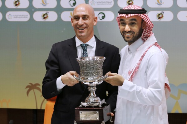 FILE - President of the Spanish Federation, Luis Rubiales, left, and Saudi General Sport Authority GSA chairman Prince Abdulaziz bin Turki Al-Faisal carry the Spanish super cup during a press conference in Jiddah Saudi Arabia, Wednesday, Dec. 18, 2019. Spanish police have arrested at least six people and raided the offices of the Spanish soccer federation as part of a corruption and money laundering investigation that includes suspicions regarding the federation’s deal with Saudi Arabia to take the Spanish Super Cup to the Middle Eastern country. Spain’s Guardia Civil said that they raided the federation’s offices near Madrid and a residence belonging to former federation president Luis Rubiales in the southern city of Granada. Police said that Rubiales was not among the six arrested. (AP Photo/Amr Nabil, File)