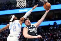 Dallas Mavericks guard Luka Doncic (77) gets the ball jammed against the backboard as he...