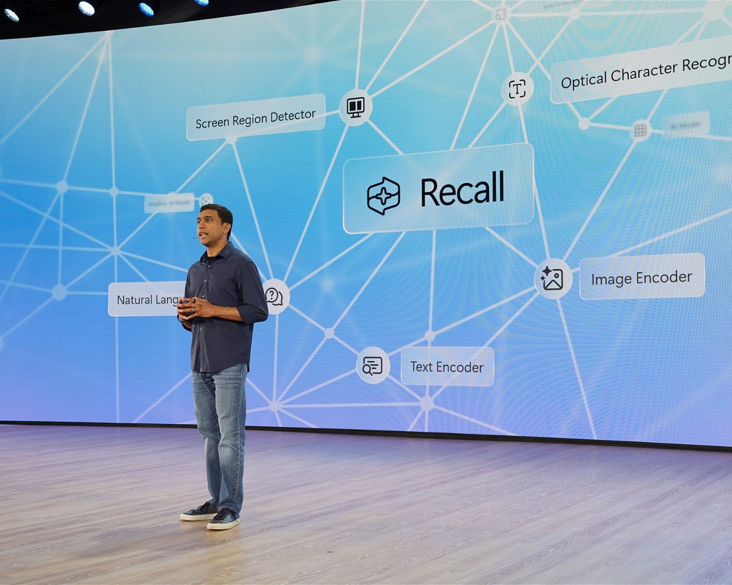 stage with recall logo on big screen, Microsoft VP for Windows and Devices Pavan Davuluri on stage