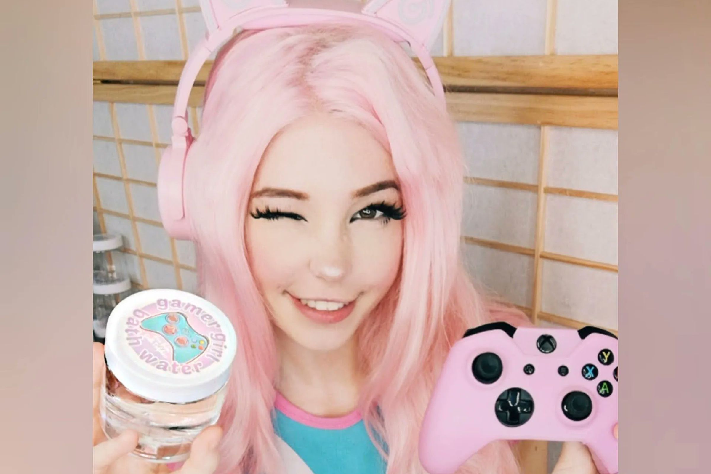 Photo of Belle Delphine, an adult content creator, sitting in a bathtub in a bathing suit holding up a controller and a jar of her bathwater.