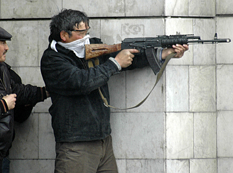 Un hombre sin identificar apunta su arma en las calles de Bishkek, Kirguistn. | Ap