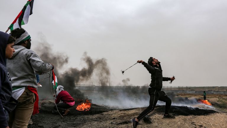 A Palestinian protester using a slingshot to target Israeli forces