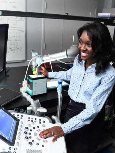 John C. Malone assistant Professor Muyinatu (Bisi) Bell, works with an imaging device in her lab.