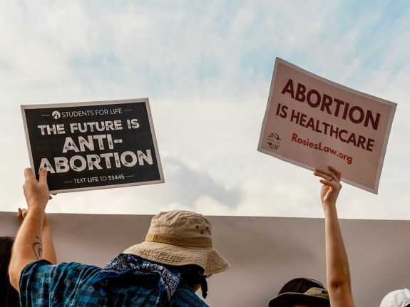 Demonstrators hold pro-life and pro-choice signs