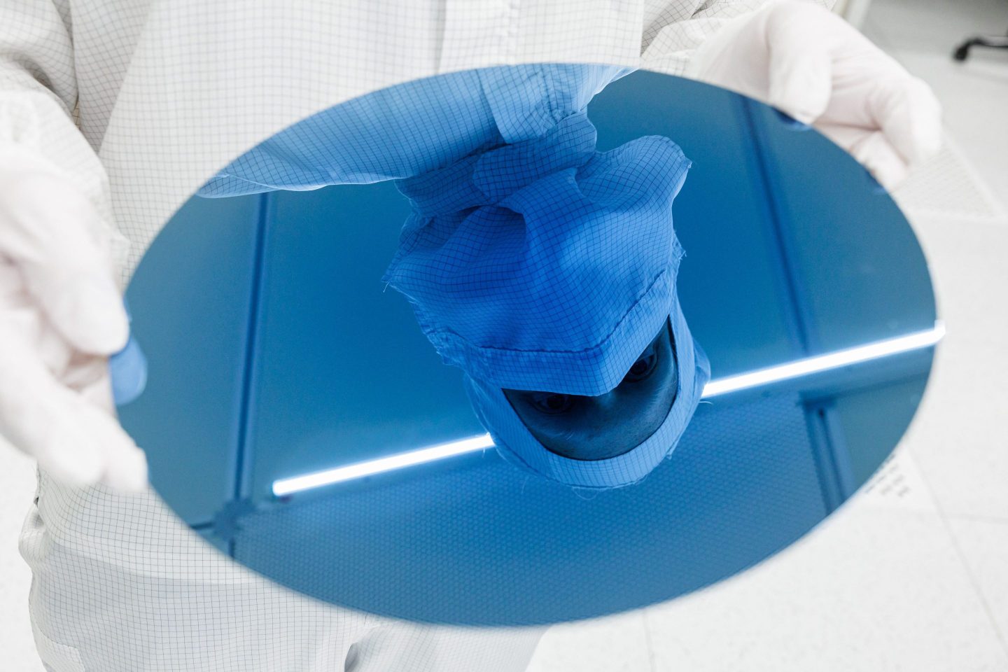An employee of German semiconductor manufacturer Infineon Technologies AG holds a 300mm test wafer in a clean room at the company&#8217;s plant in Dresden, eastern Germany, on April 26, 2023. &#8211; German chipmaker Infineon will launch the groundbreaking of a new factory, the Smart Power Fab, in Dresden on May 2, 2023. Supply chain snarls during the Coronavirus pandemic have exposed how over-reliant Europe has become on chip imports from abroad in recent years, disrupting numerous industries that depend on the components. The European Union in 2022 launched a plan known as the &#8220;Chips Act&#8221;, which aims to double Europe&#8217;s market share in semiconductors by 2030. (Photo by JENS SCHLUETER / AFP) (Photo by JENS SCHLUETER/AFP via Getty Images)