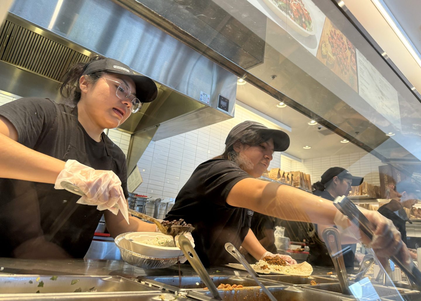 SAN RAFAEL, CALIFORNIA &#8211; APRIL 01: Workers fill food orders at a Chipotle restaurant on April 01, 2024 in San Rafael, California. A new minimum wage law went into effect in California today that calls for fast food restaurants with at least 60 locations nationwide to pay employees a minimum of $20 per hour at their stores in California. (Photo by Justin Sullivan/Getty Images)