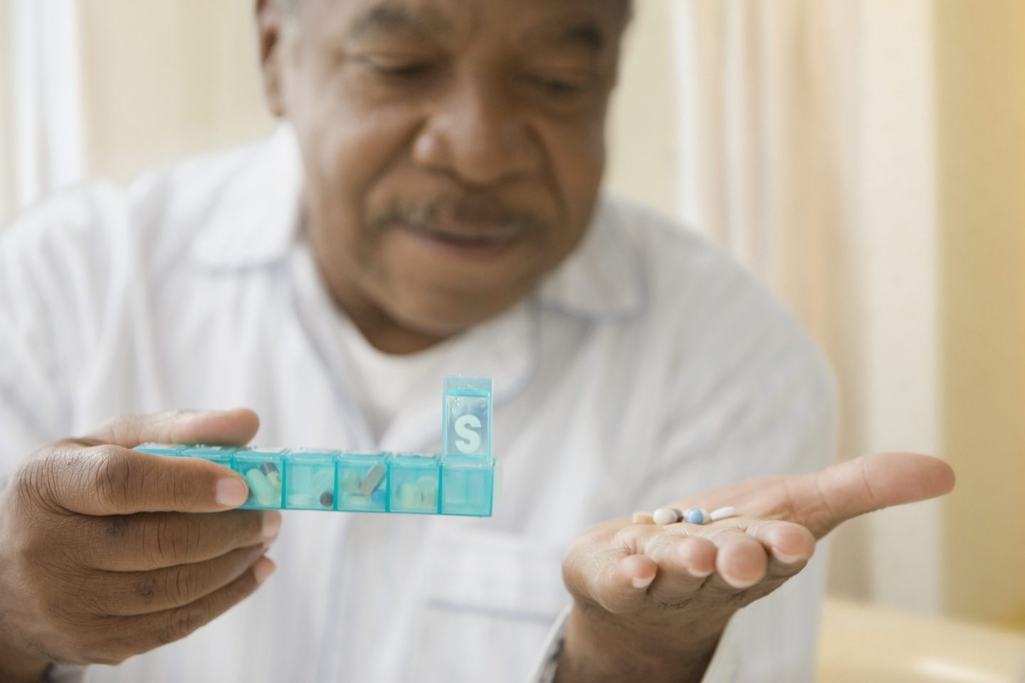 Senior man holding several prescription medications
