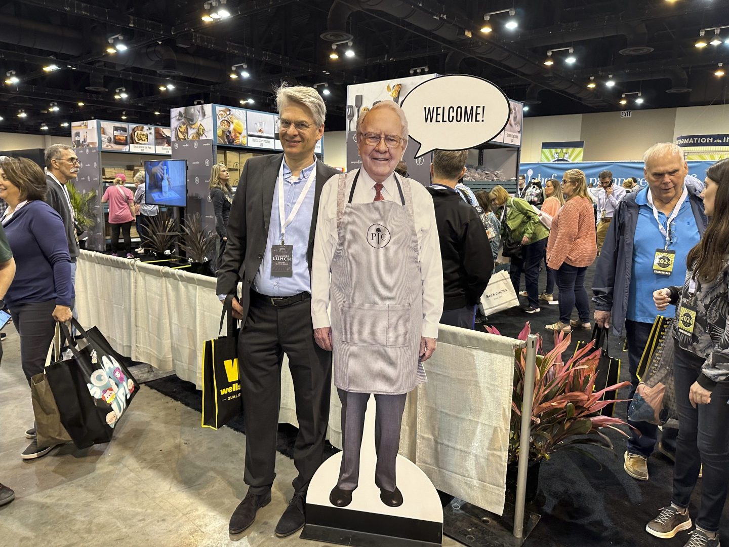 Berkshire Hathaway shareholders pose with a cutout poster of CEO Warren Buffett Friday, May 3, 2024, in Omaha, Neb.,  inside the exhibit hall in Omaha where Berkshire companies sell their products.