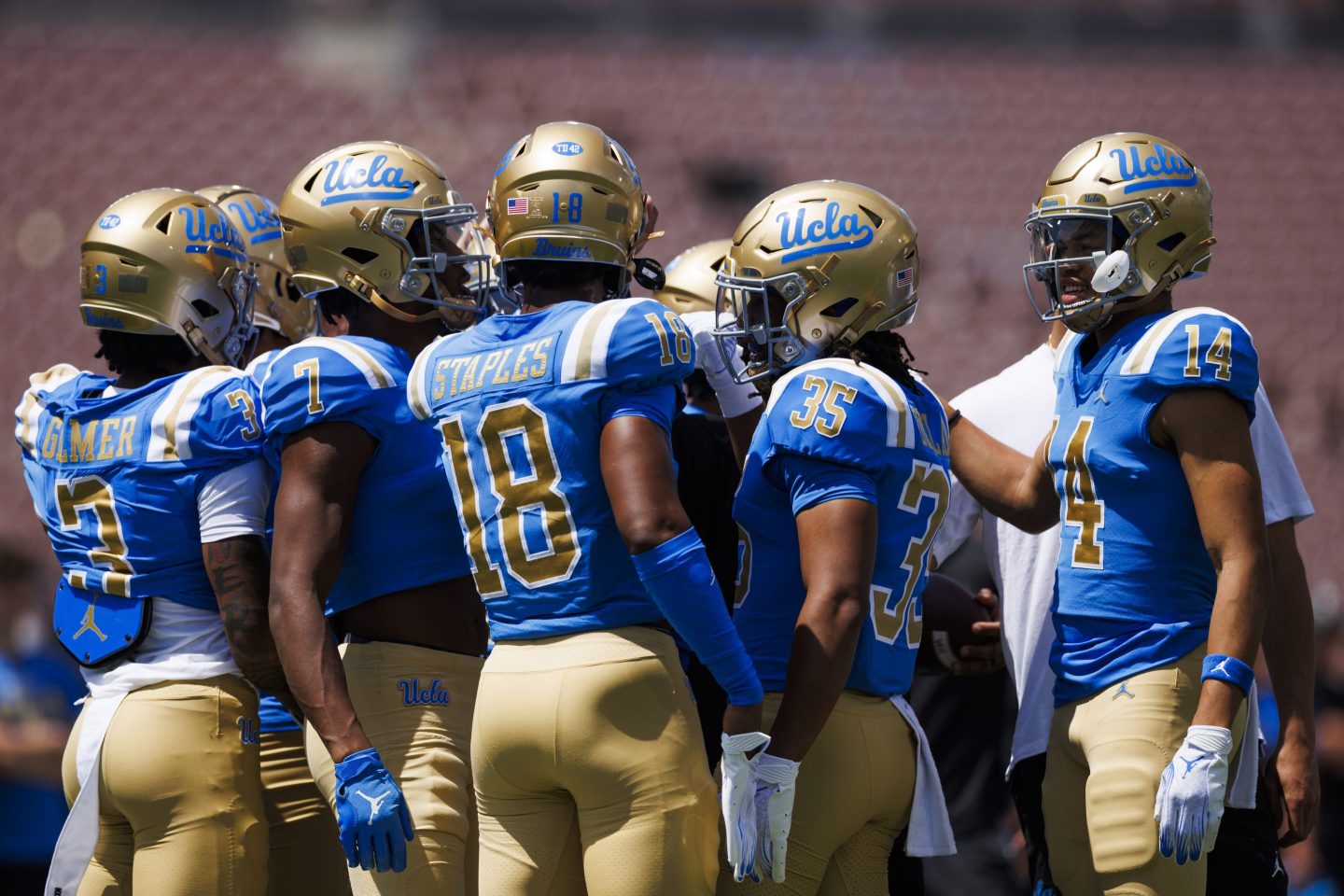 UCLA football players huddle