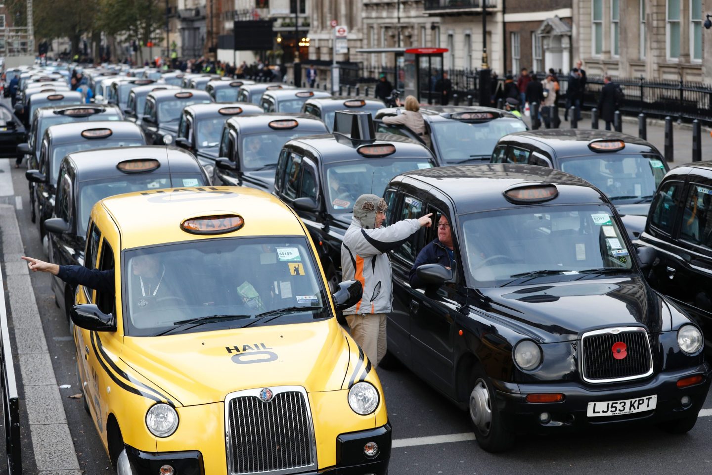 Black cab taxi drivers block a road in central London as they protest against how transport is run in the capital on November 8, 2016.