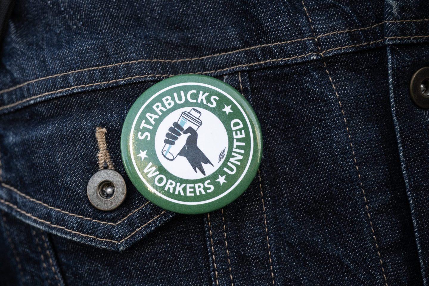 A pin showing the Starbucks Workers United union logo