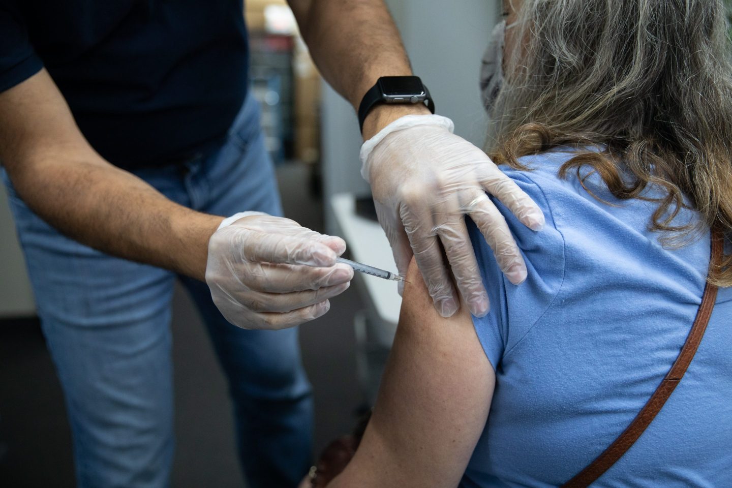 A pharmacist administers a third dose of the Pfizer-BioNTech Covid-19 vaccine to a customer at a pharmacy in Livonia, Michigan, U.S., on Tuesday, Aug. 17, 2021. Americans with weakened immune systems will be allowed to get three shots of Covid-19 vaccine after U.S. regulators authorized giving an extra dose to the most vulnerable people. Photographer: Emily Elconin/Bloomberg via Getty Images