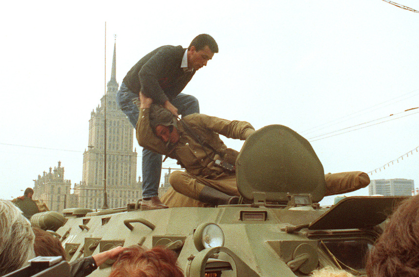 MOSCOW, RUSSIA - AUGUST 19:  A pro-democracy demonstrator fights with a Soviet soldier on top of a tank parked in front of the Russian Federation building 19 August 1991 after a coup toppled Soviet President Mikhail Gorbachev. The coup was headed 19 August by the members of the self-styled "committee for the state of emergency" or the "gang of eight", including Soviet Vice President Gennady Yanayev and KGB chief Vladimir Kryuchkov. Thousands in Moscow, Leningrad and other cities answered the same day Russian Republic President Boris Yeltsin's call to raise barricades against tanks and troops. The collapse of the coup was signaled in the afternoon 21 August when the defence ministry ordered all troops to withdraw from Moscow.  (Photo credit should read DIMA TANIN/AFP/Getty Images)