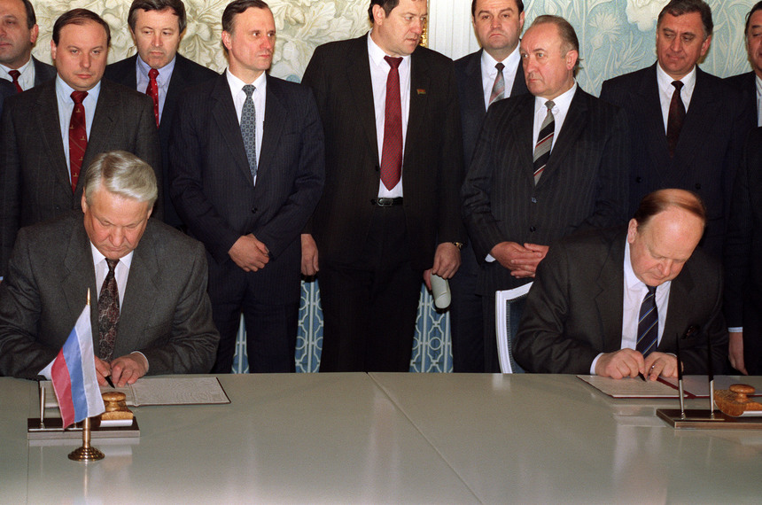 Russian President Boris Yeltsin (L) and Belarus's Supreme Soviet Chairman Stanislav Shushkevich (R) sign a document 08 December 1991 stating that "the Soviet Union as a geopolitical reality [and] a subject of international law has ceased to exist." The document simultaneously announces the creation of a new entity in the post-USSR territory - the Commonwealth of Independent States. The document - now widely known as the Belavezha Agreement - was signed in a government villa in Viskuli in Belarus's Belavezha Forest, which is Europe's only primeval wooded area. (Photo credit should read DAVID BRAUCHLI/AFP/Getty Images)