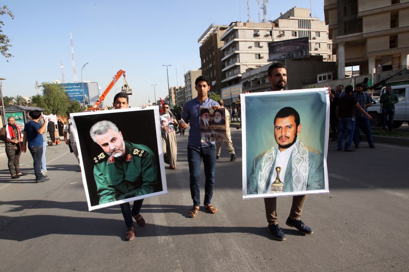 Iraqis hold portraits of Iranian Gen. Qassem Suleimani (left) and a Yemeni Houthi leader (right) during a demonstration in Baghdad against the Saudi-led coalition carrying out airstrikes on targets across Yemen on March 31, 2015.