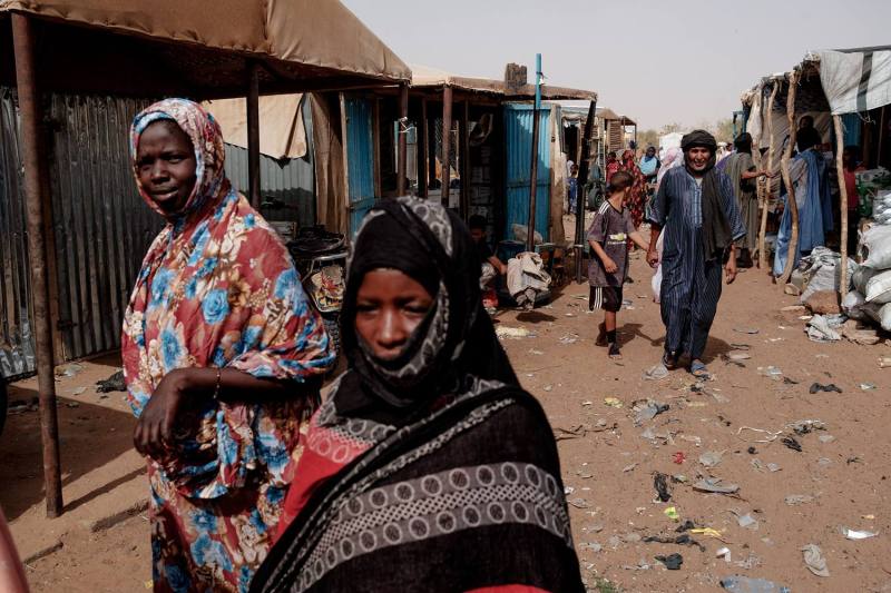 People fleeing violence in Mali walk through the weekly market in the M'Berra refugee camp in Bassikounou, Mauritania, on June 7, 2022.