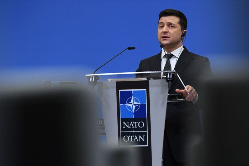 Ukrainian President Volodymyr Zelensky, standing behind a podium, talks during a press conference in Brussels.