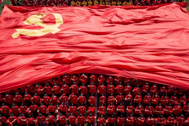 University students display a flag of the Communist Party of China to mark the party's 100th anniversary during an opening ceremony of the new semester in Wuhan in China's central Hubei province on Sept. 10, 2021.