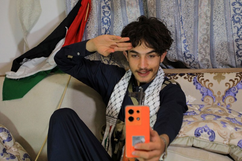 Rashid Al-Haddad, 19, a Yemeni TikToker and influencer, who has been dubbed "Tim-Houthi Chalamet" for his resemblance to Timothée Chalamet, talks to a friend on the phone during an interview at his home in the Houthi-controlled capital, Sana'a.