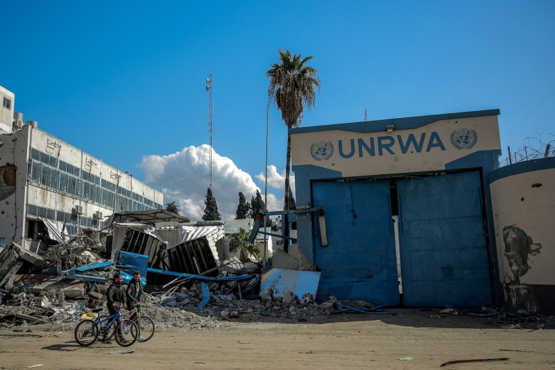 People walk past the damaged headquarters of the United Nations Relief and Works Agency for Palestine Refugees (UNRWA) in Gaza City on Feb. 15.