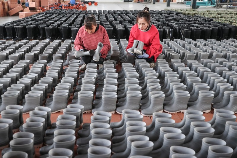 Employees check rain boots for export at a shoe factory in Lianyungang, China, on March 13.