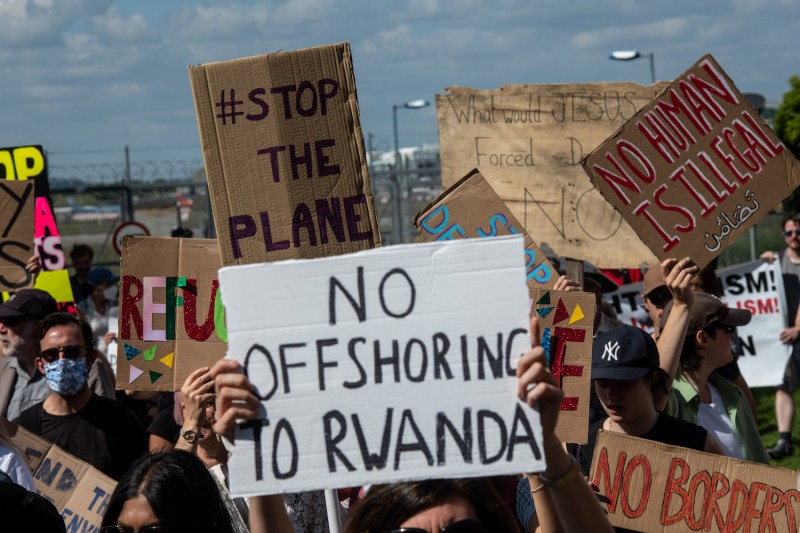 Protesters chant and hold placards against the U.K. deportation flights to Rwanda near Brook House Immigration Removal Centre on June 12, 2022 in London.