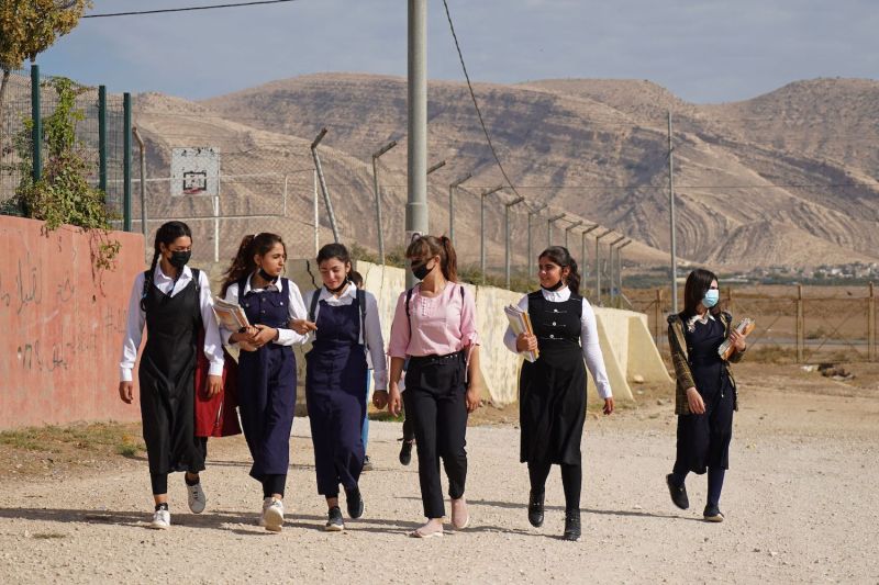 Girls walk to class on the first day of school in a Yazidi displacement camp about 9 miles from the city of Dohuk in the Kurdistan Region of Iraq on Nov. 1, 2021.