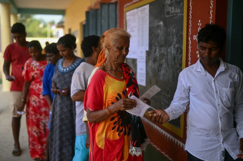 Voters wait to cast their ballots outside a polling station during the third phase of voting for the India's general election in Sadashivapura village in Karnataka, India.