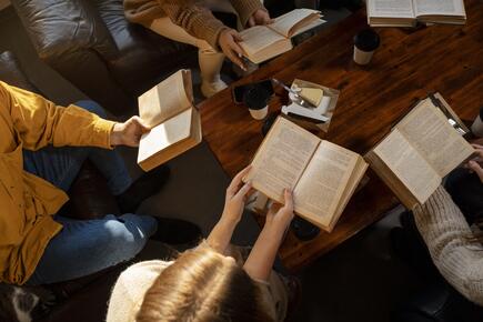people reading books around a coffee table