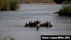 Migrants cross the Rio Grande river into the United States at Eagle Pass, Texas, in May.