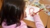 An HIV-infected child draws a Red Ribbon, the international symbol of HIV and AIDS awareness, at the Center for Maternity and Childhood in Shymkent in this 2010 photo.