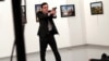Mevlut Mert Altintas, an off-duty policeman, shouts after shooting Andrei Karlov, the Russian ambassador to Turkey (right), at an art gallery in Ankara on December 19, 2016.