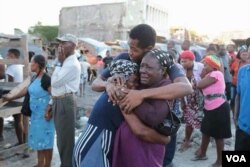 Vendors who lost merchandise in the Iron Market fire console each other after arriving on the scene, Feb. 13, 2018. (R.M. Givens/VOA Creole)