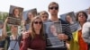 FILE - Relatives, friends and supporters hold portraits of French teacher Cecile Kohler, detained along with her partner Jacques Paris in Iran, during a rally in their support in Paris, May 14, 2023. 