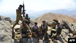 FILE - Afghan resistance movement and anti-Taliban forces take a break as they patrol on a hilltop in the Darband area of Anaba district, in Afghanistan's Panjshir province, Sept. 1, 2021.