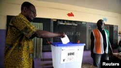A man casts his vote at a polling station during the legislative elections in Abidjan, Ivory Coast, Dec. 18, 2016. 