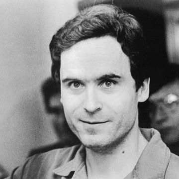 ted bundy waves and looks directly at the camera, he is wearing a collared shirt in the black and white photo