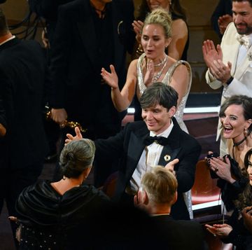 emily blunt, cillian murphy and several other people celebrate while standing and clapping