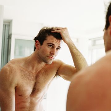 close up of a man checking his hair in the mirror