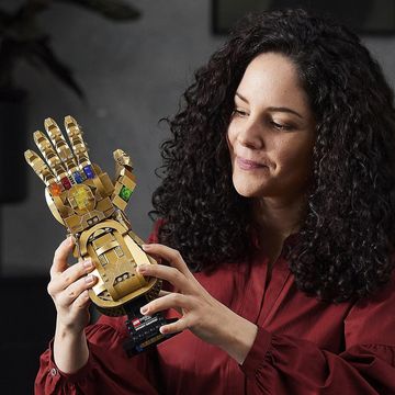 a woman holding a lego avengers infinity gauntlet