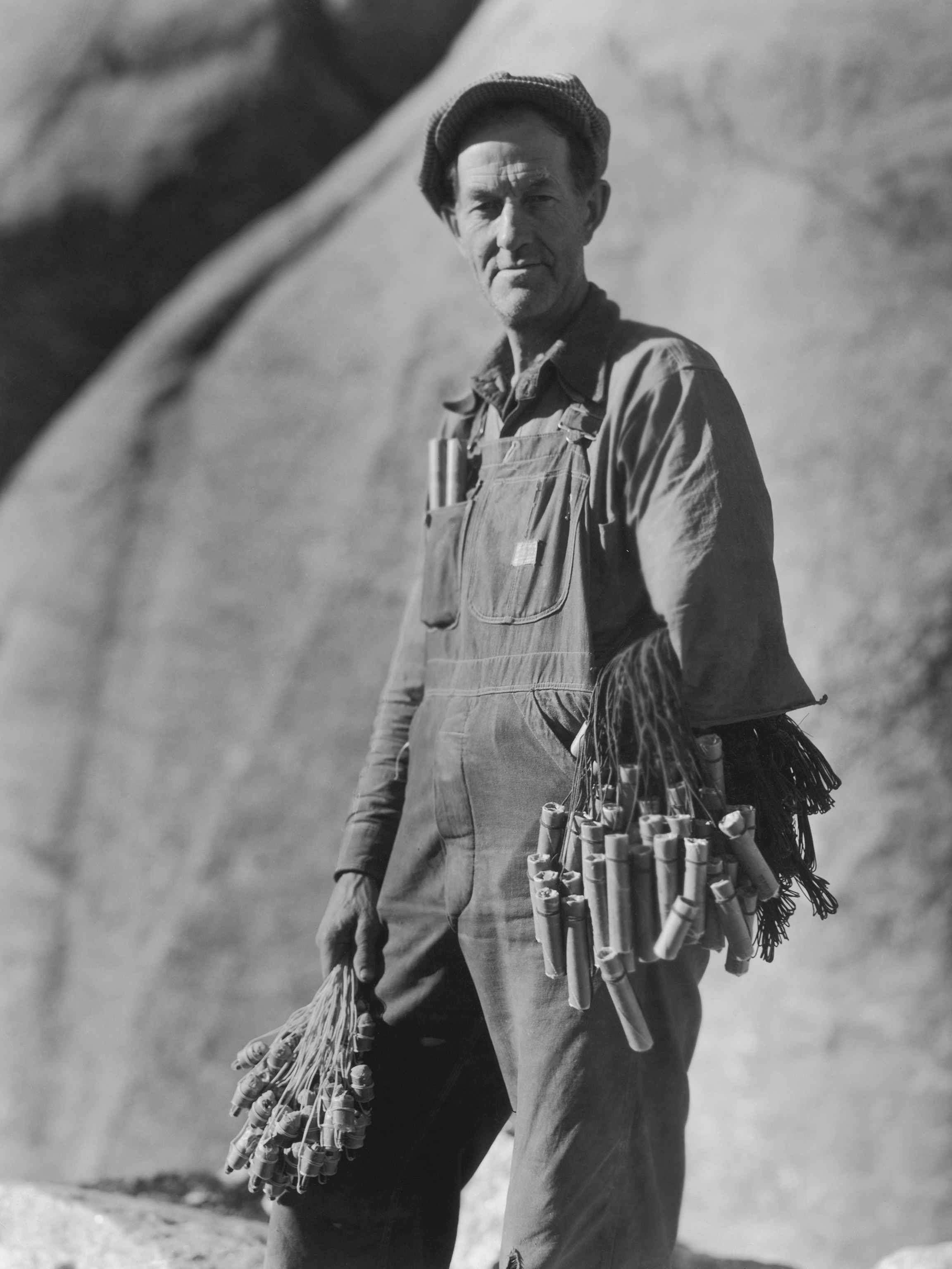 a person working on Mount Rushmore holding dynamite and detonators