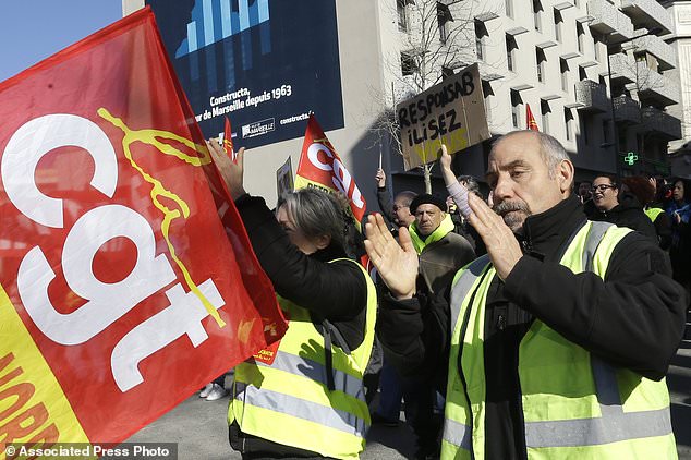Yellow vest protesters join unionists from the CGT (General Working Confederation) during a demonstration in Marseille, southern France, Tuesday, Feb. 5, 2019. French public workers are striking in protest against French President Emmanuel Macron's policies and demonstrations are taking place across the country with the CGT labor union calling for a general strike. (AP Photo/Claude Paris)