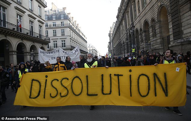 Demonstrators hold a banner during a protest called by the CGT (General Working Confederation) union, Tuesday, Feb. 5, 2019 in Paris. Workers, public servants, and retired people were invited to march during a strike called by the CGT (General Working Confederation) union. (AP Photo/Michel Euler)