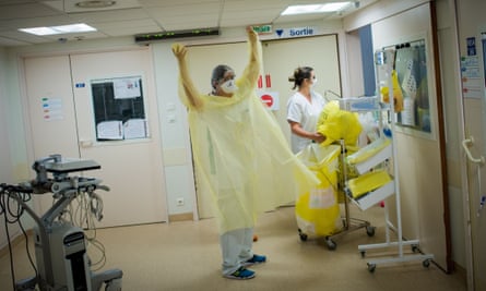 A nurse prepares to enter a room to care for a coronavirus patient at a hospital in Nantes, France